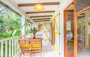 Relax in a serene outdoor space surrounded by lush tropical plants and a decorative wall piece.