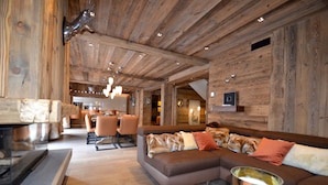 A modern interior with a wooden ceiling, a sectional sofa, and a fireplace.