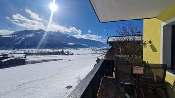 Ein Balkon mit Blick auf verschneite Felder und Berge.