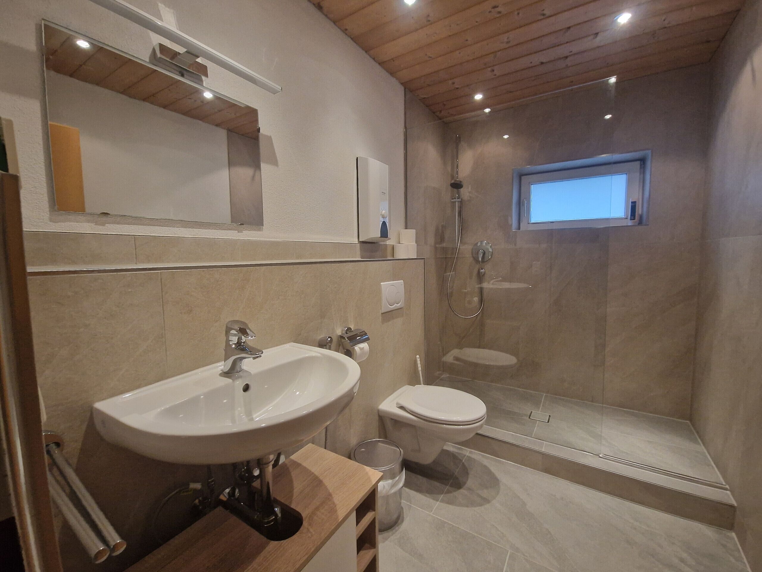 Ein modernes Badezimmer mit Waschbecken, Toilette und Dusche.
