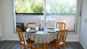 Een eettafel met een tafelkleed met stippen, omringd door houten stoelen, gedekt voor vier personen.