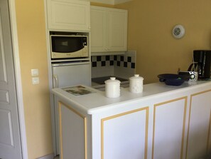 Kitchen area with a refrigerator, microwave, and coffee maker.