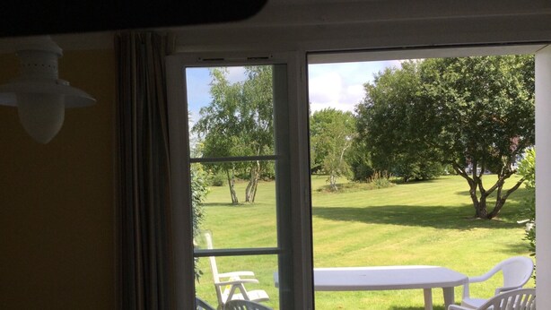 A room with a sliding glass door leading to an outdoor patio area with a table and chairs. - House 2 bedrooms Pierre et Vacances Port Bourgenay Domaine du Moulin (Talmont -Saint-Hilaire)