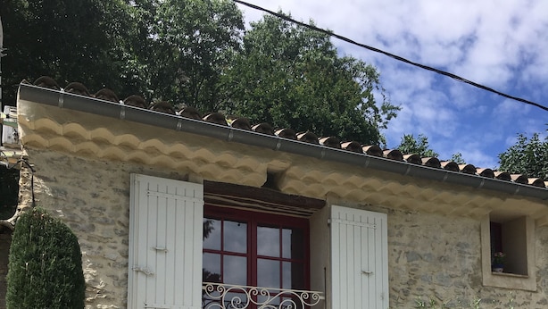 A stone building with a red door, white shutters, and a balcony. - House "Ciboulette (Mirabel-aux-Baronnies)