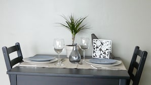 A dining table with four chairs, a vase with a plant, and a decorative card. - Beautiful studio Beautiful view (Strasbourg)