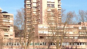 A tall residential building with multiple balconies, surrounded by trees and other buildings. - Beautiful studio Beautiful view (Strasbourg)