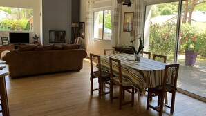 Un salón amplio con sofá, televisor y una mesa de comedor con sillas.