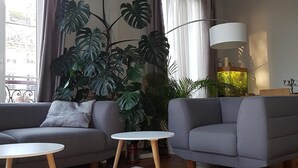 A living room with two grey sofas, a white coffee table, and a large potted plant. - ❤️❤️Paris Center Bastille Magnificient view Flat 3 rooms 2 bedrooms (Paris)