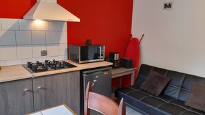 Cocina compacta con microondas, tostadora y cafetera.