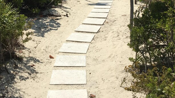 A sandy pathway leading to a beach with palm trees and clear blue sky. - Gated Villa w Private Pool, Outdoor Shower, BBQ • Easy Walk to GraceBay Beach (Providenciales)