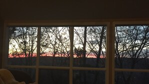 A room with a large window overlooking a tree-lined area. - Mountainside Spa With View’s  (Bushkill)