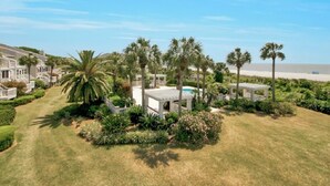 A residential property with a swimming pool, palm trees, and a beach view. - Award-Winning Resort Amenities | Beach Club Villa 12 (Isle of Palms)