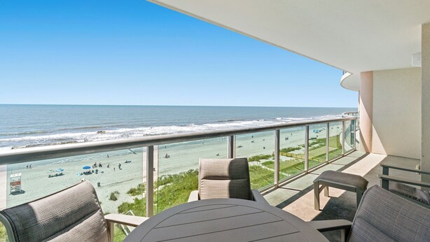 Ein Balkon mit Blick auf Strand und Meer.