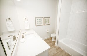 Bathtub, hair dryer, towels, shampoo