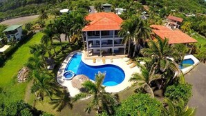 Ein Resort mit großem Schwimmbad, mehreren Gebäuden und üppiger Bepflanzung.