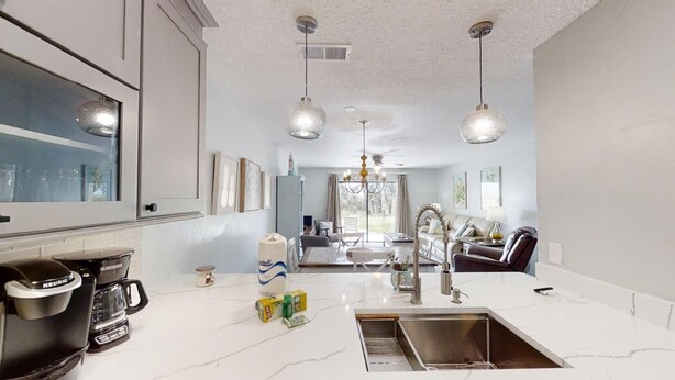 A modern kitchen with a large island, built-in appliances, and pendant lighting. - Ponce Landing 5 - Ocean front 2 bedroom townhome with garage (St. Augustine)