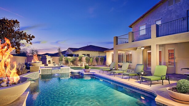 A swimming pool with a fire feature, outdoor seating, and a building with a balcony. - Unbeatable Location, Heated Pool, 2 Primary Suites, Game Room, Hot Tub, More! (Phoenix)