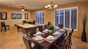 A dining room with a pool table, a chandelier, and large windows with blinds. - Unbeatable Location, Heated Pool, 2 Primary Suites, Game Room, Hot Tub, More! (Phoenix)