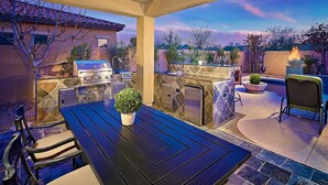 An outdoor patio with a grill, seating, and a view of the landscape. - Unbeatable Location, Heated Pool, 2 Primary Suites, Game Room, Hot Tub, More! (Phoenix)