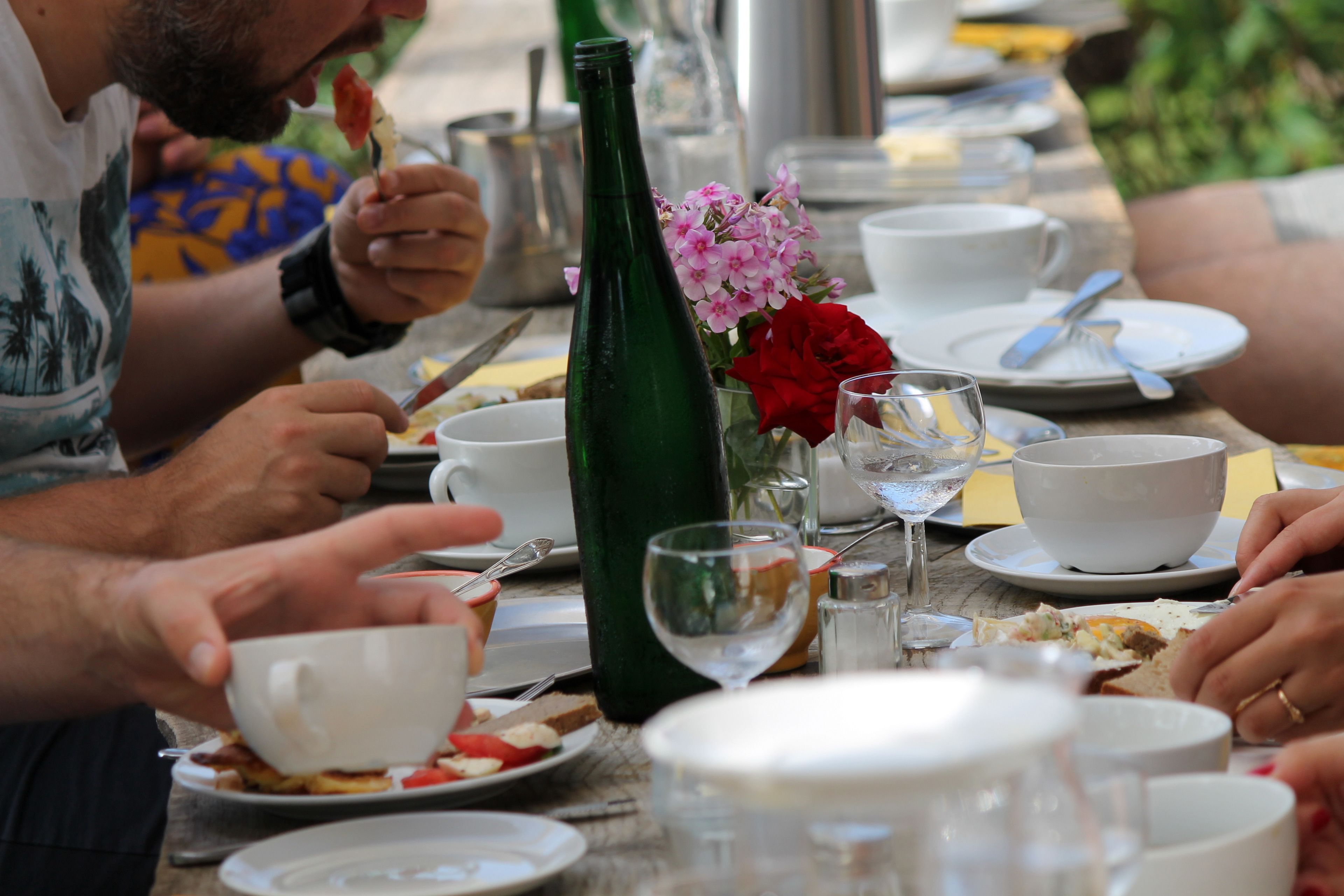 Una mesa de comedor con platos, tazas y una botella.