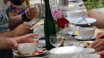 Una mesa de comedor con platos, tazas y una botella.