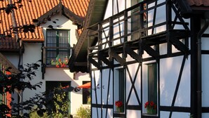 A traditional half-timbered house with a steeply pitched roof, dormer windows, and flower boxes on the upper windows. - Landhaus Masurische Schweiz (Kowale Oleckie)