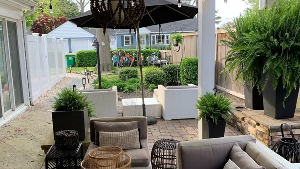 An outdoor patio area with a grey sofa, wicker furniture, and potted plants. - Walking Distance to Ocean/Beaches, Heated/Saltwater pool-pool open 4/1-11/1 (Rehoboth Beach)
