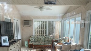 A spacious living room with a large sofa, a coffee table, and a television on a wooden cabinet. - Walking Distance to Ocean/Beaches, Heated/Saltwater pool-pool open 4/1-11/1 (Rehoboth Beach)