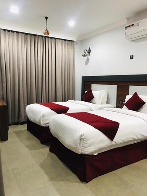 A hotel room with a double bed, a bedside table, a lamp, and a window with curtains. - Nizwa Residence Hotel Apartment (Nizwa)