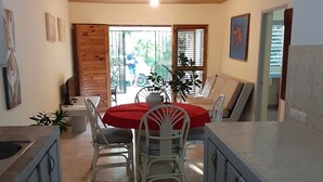 A kitchen with a dining area, wooden ceiling, and a view of the outside.