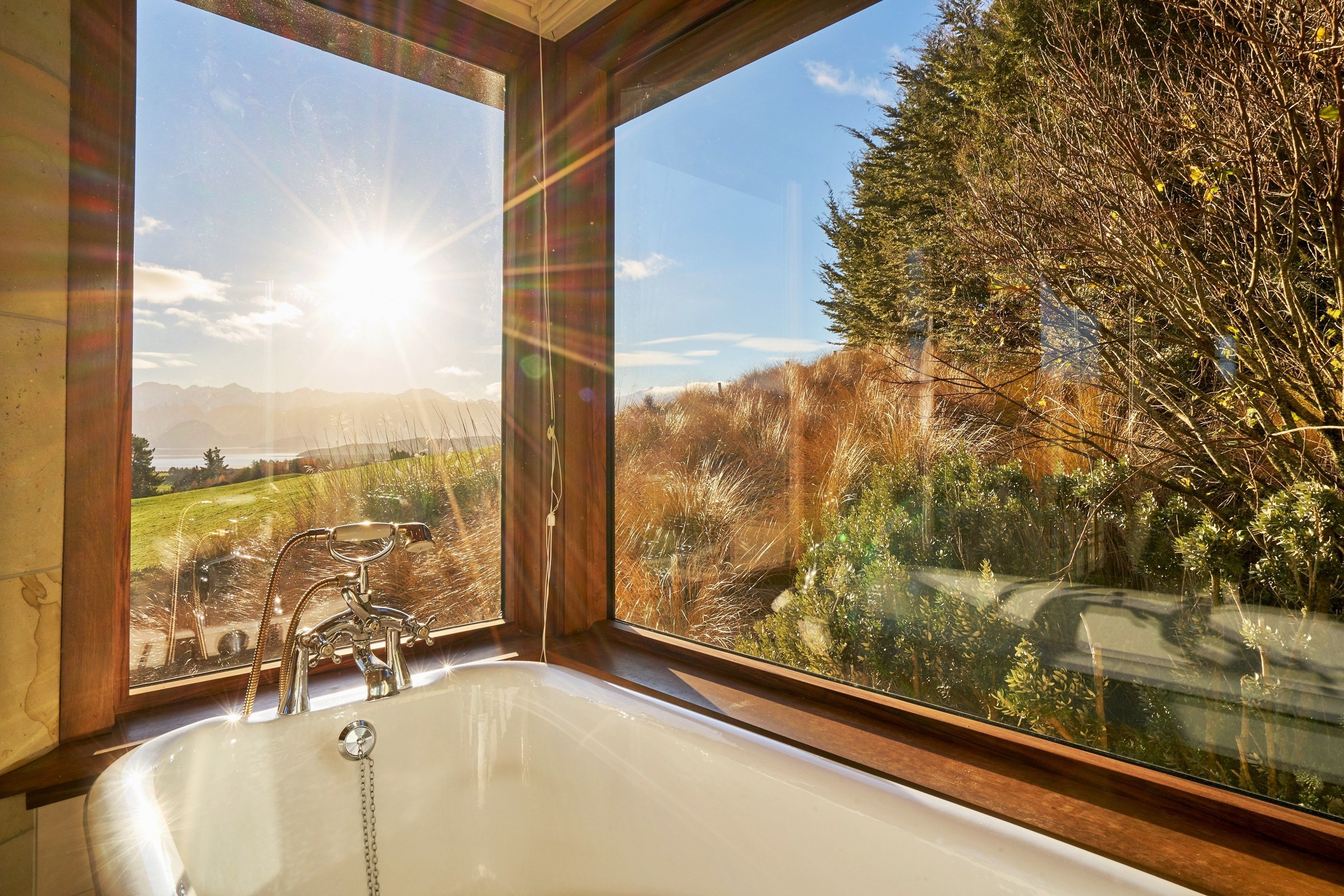 A bathroom with a large window offering a view of a natural landscape.