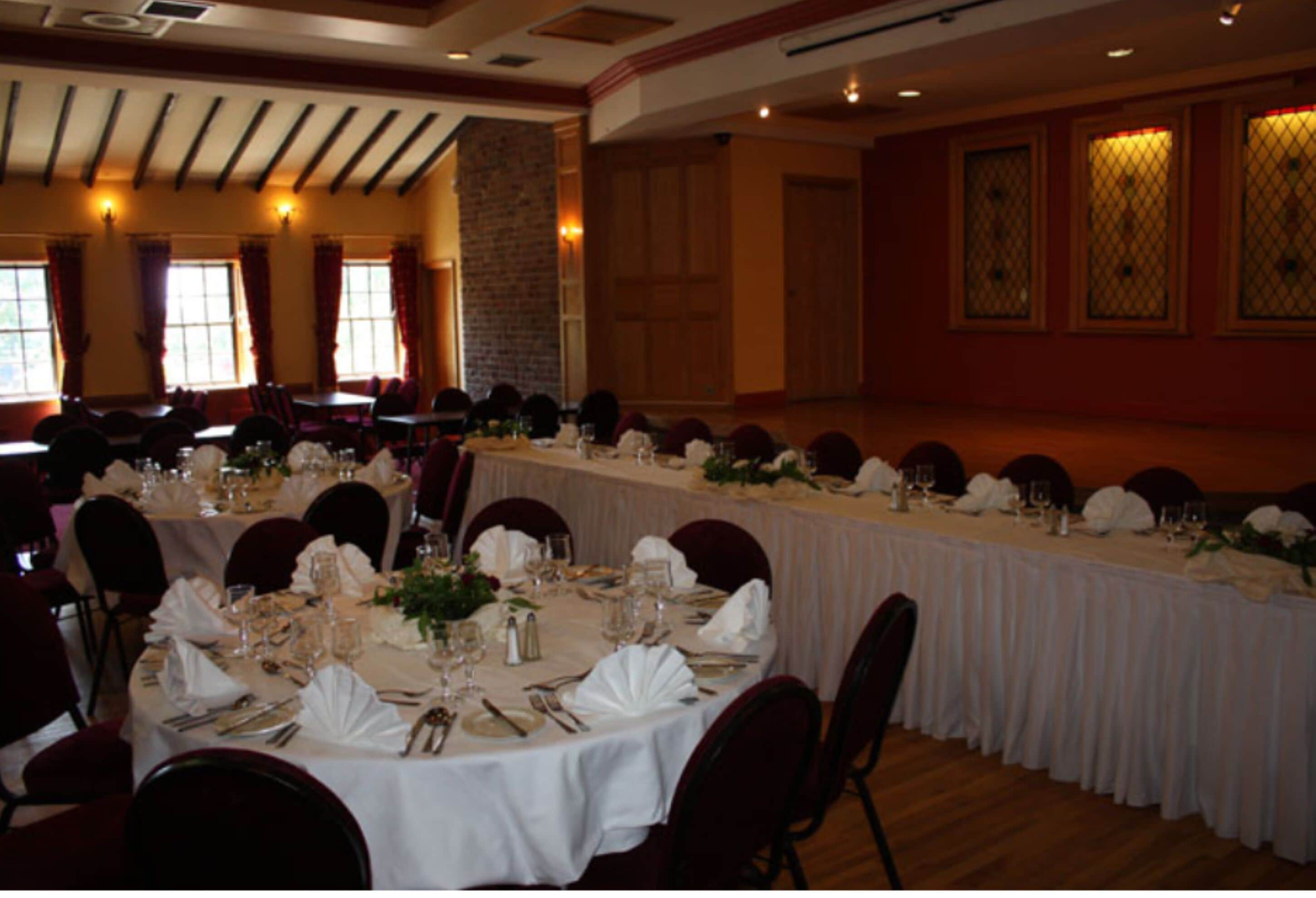 A long banquet table set for a formal event, with chairs arranged around it.