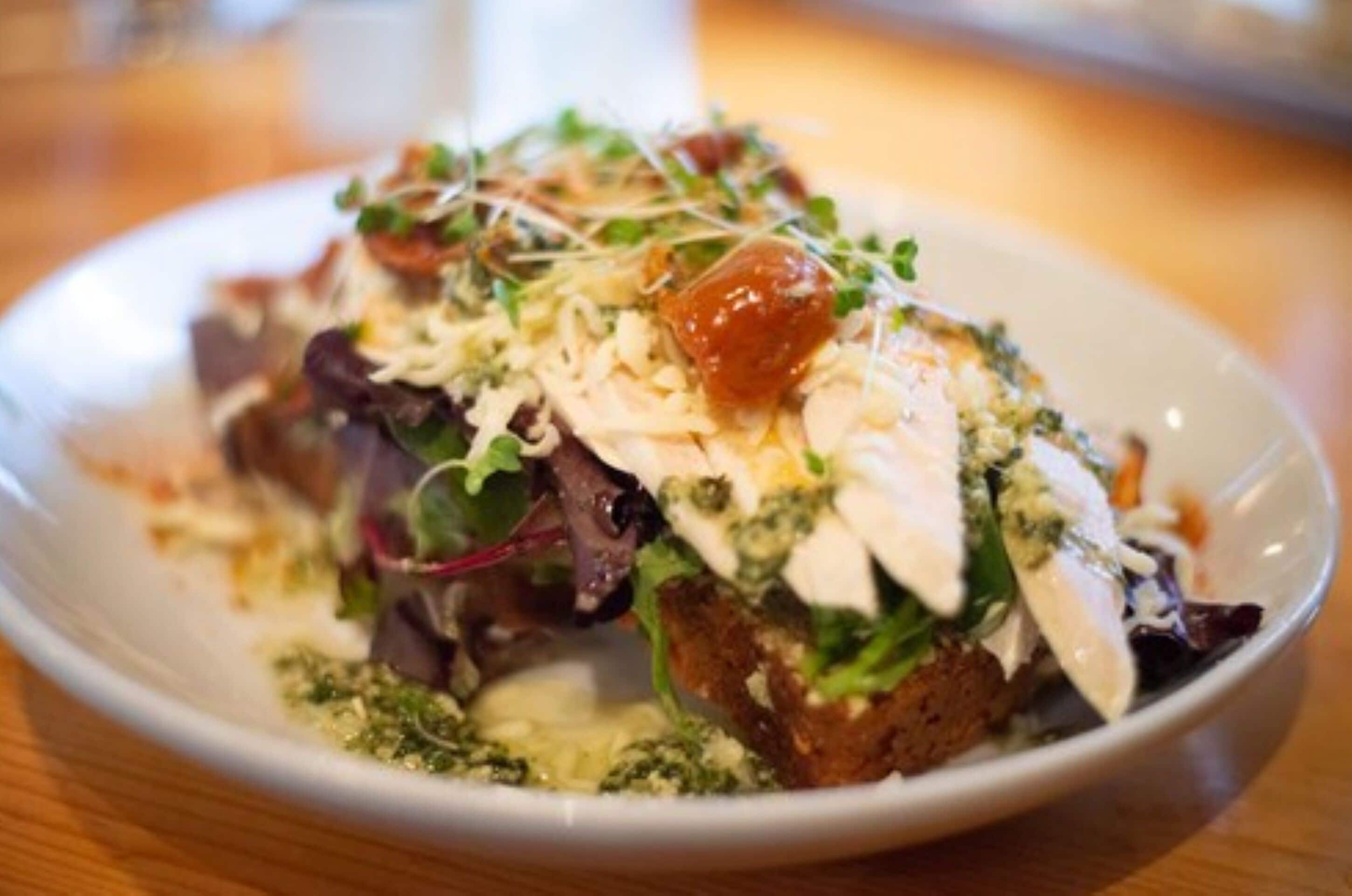 A plate of food with various toppings and greens.