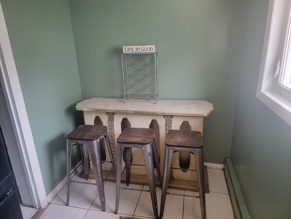 A corner with a marble counter, three stools, and a sign that reads 'Life is Good.'