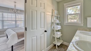 A bathroom with a white bathtub, a white sink, and a window with a view of trees. - Great location in Old Mill District ! ♥ Fenced Backyard,  ♥ Pet Friendly! (Bend)