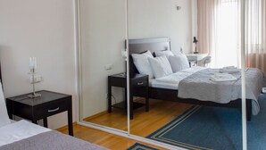 A hotel room with a bed, bedside table, and a mirror. - Tbilisi Center Private 4-room Apartment (Dzveli Tbilisi)