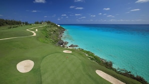 A golf course with a clear view of the ocean and a sandy beach. - Cottage Priv. Pool & Tennis Beach 5 min Central (Paget)