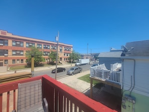 Et boligområde med en rød bygning, en hvid varevogn og et hus med hvid stakit.