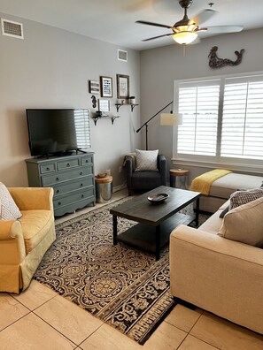 Relax in a comfortable seating area with a sofa and armchair, perfect for unwinding or socializing.