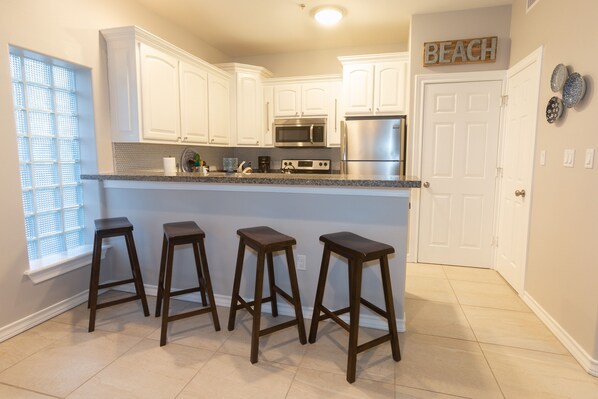 Enjoy cooking in this well-equipped kitchen with a central island and stainless steel appliances.