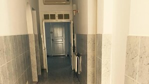 A narrow hallway with tiled floors and walls, leading to a door at the end. - A large quiet blue flag apartment with free wifi modern and well equipped (Sousse)