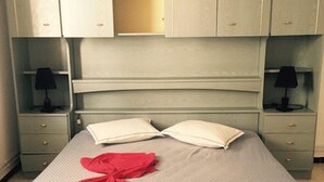 A bed with a grey headboard, two bedside tables with lamps, and a red blanket on the bed. - A large quiet blue flag apartment with free wifi modern and well equipped (Sousse)