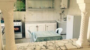 A kitchen with white cabinets, a gas stove, a sink, and a refrigerator. - A large quiet blue flag apartment with free wifi modern and well equipped (Sousse)