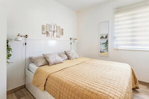 A bedroom with a bed, bedside lamps, a window with blinds, and wall-mounted shelves. - Apartment with a Terrace and Free Parking - Beach Nearby (Split)