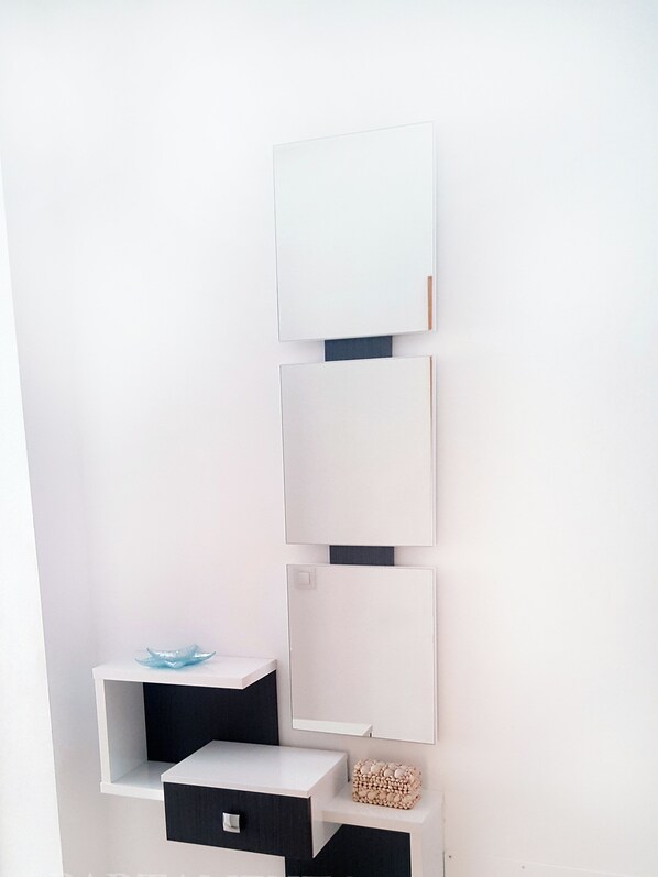 A wall-mounted shelving unit with multiple compartments, including a drawer and a small shelf with decorative items. - Live the Charm of Nerja – Steps from the Beach and Historic Center (Nerja)