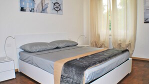 A bedroom with a bed, a nightstand, a window with sheer curtains, and wall art. - Entire apartment CASA FELICE 9 Places Free Parking and Free Wi-Fi Included (Venezia)