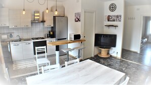 A modern kitchen with stainless steel appliances, a wooden island, and a dining area with a white table and chairs. - Entire apartment CASA FELICE 9 Places Free Parking and Free Wi-Fi Included (Venezia)