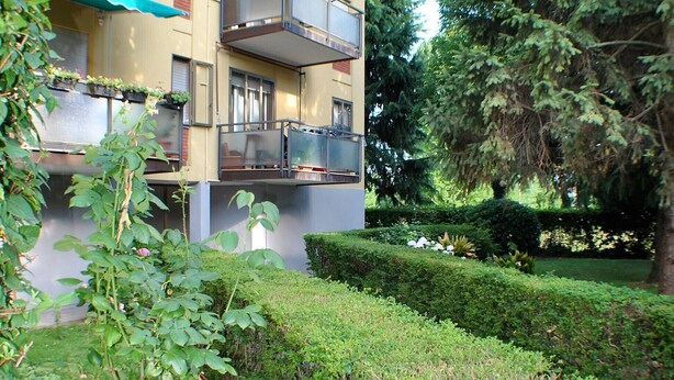 A multi-story residential building with balconies, a well-maintained garden, and a hedge. - Entire apartment CASA FELICE 9 Places Free Parking and Free Wi-Fi Included (Venezia)