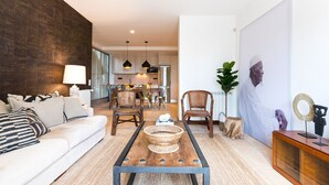 Een moderne woonkamer met een bank, salontafel en een eethoek.