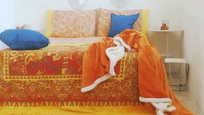 Un lit avec une couvre-lit à motifs, deux oreillers et une couverture.